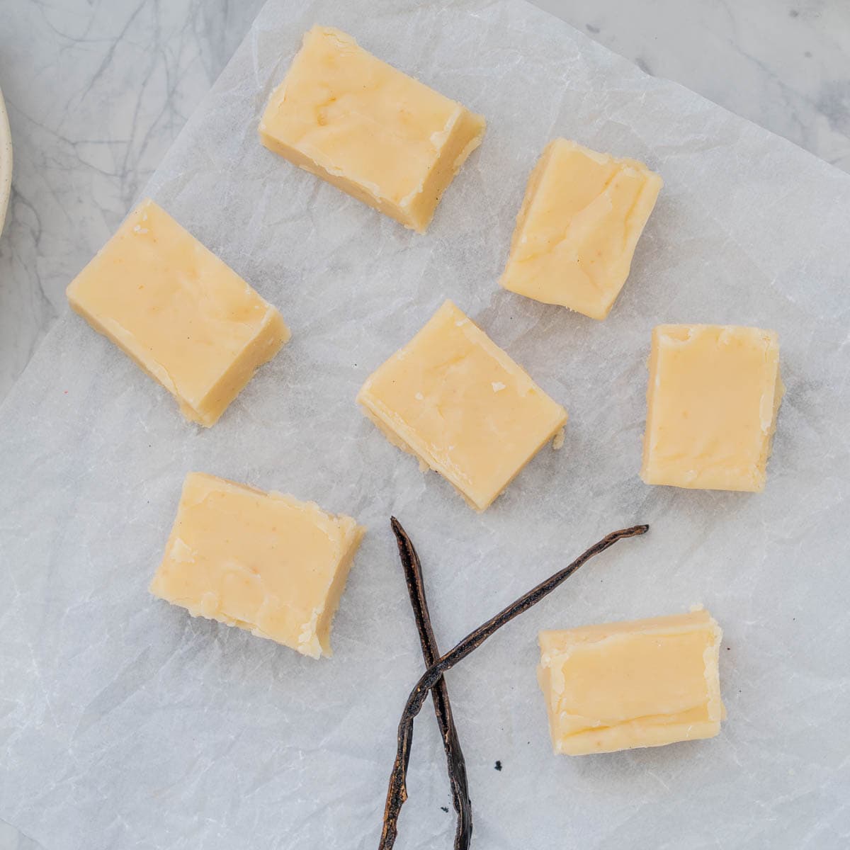 Slices of vanilla fudge placed on a sheet of crinkled baking paper 