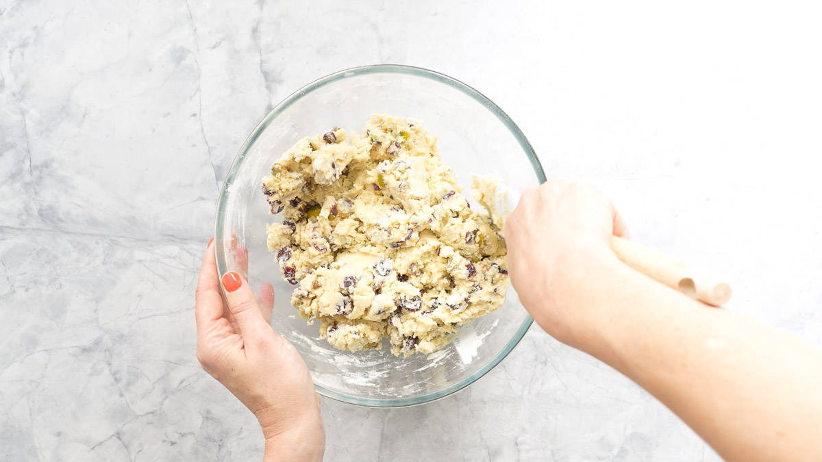 Cookie dough studded with pistachio and cranberries in a mixing bowl 