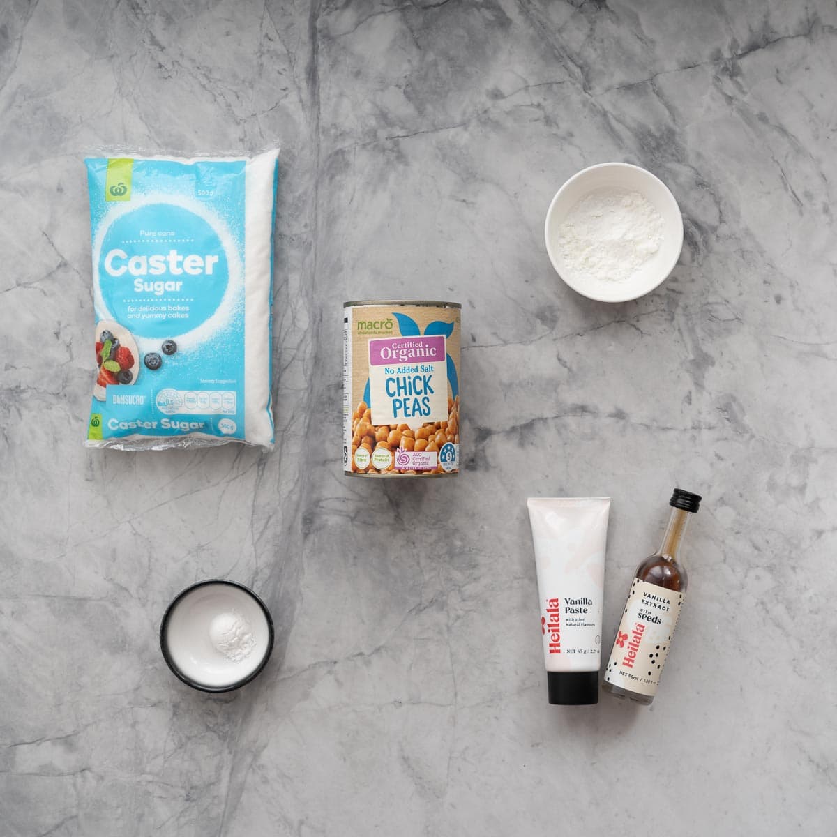 The ingredients to make a vegan pavlova laid out on a marble bench top.
