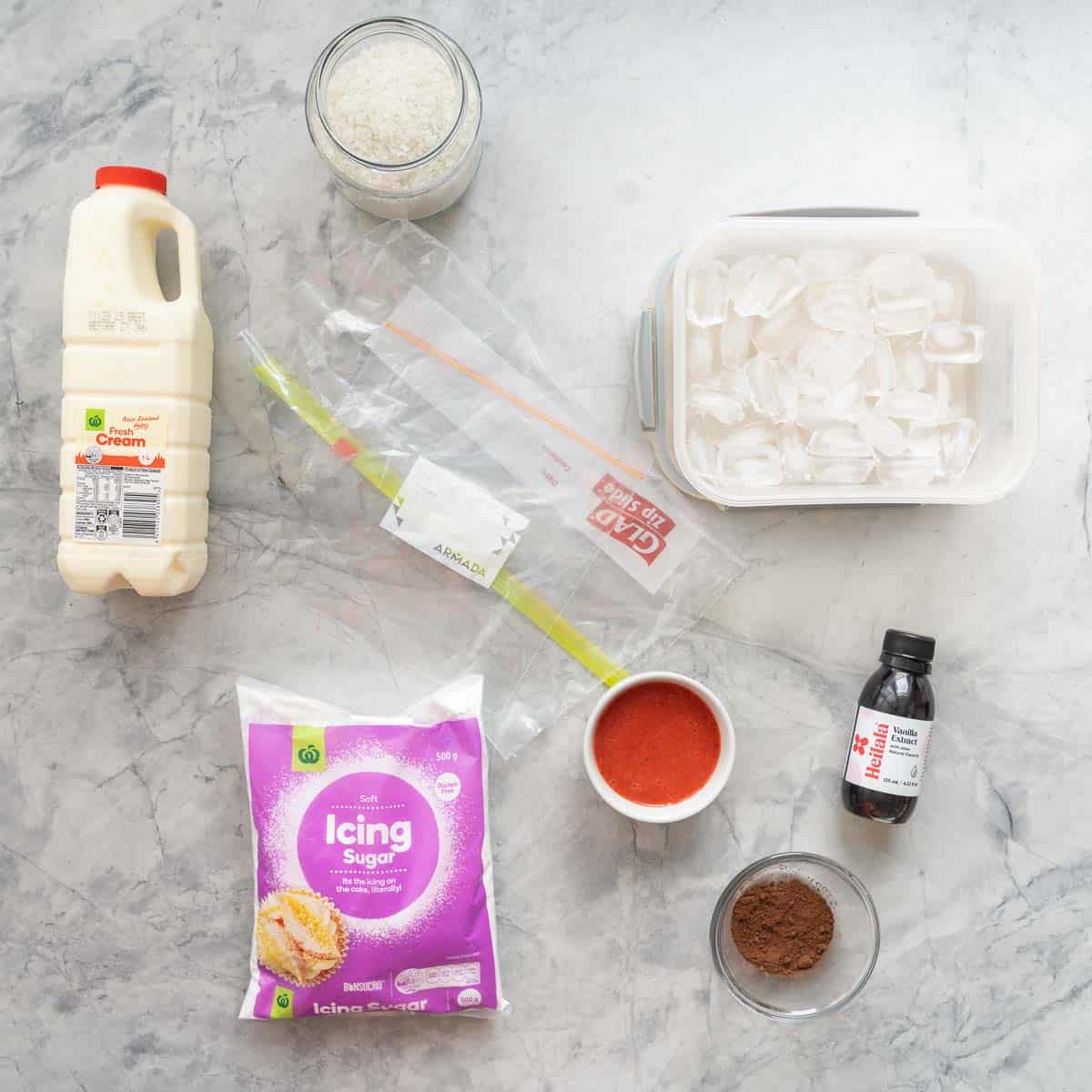 The ingredients required to make ice cream in a bag laid out on a bench including zip lock bags ice and salt.