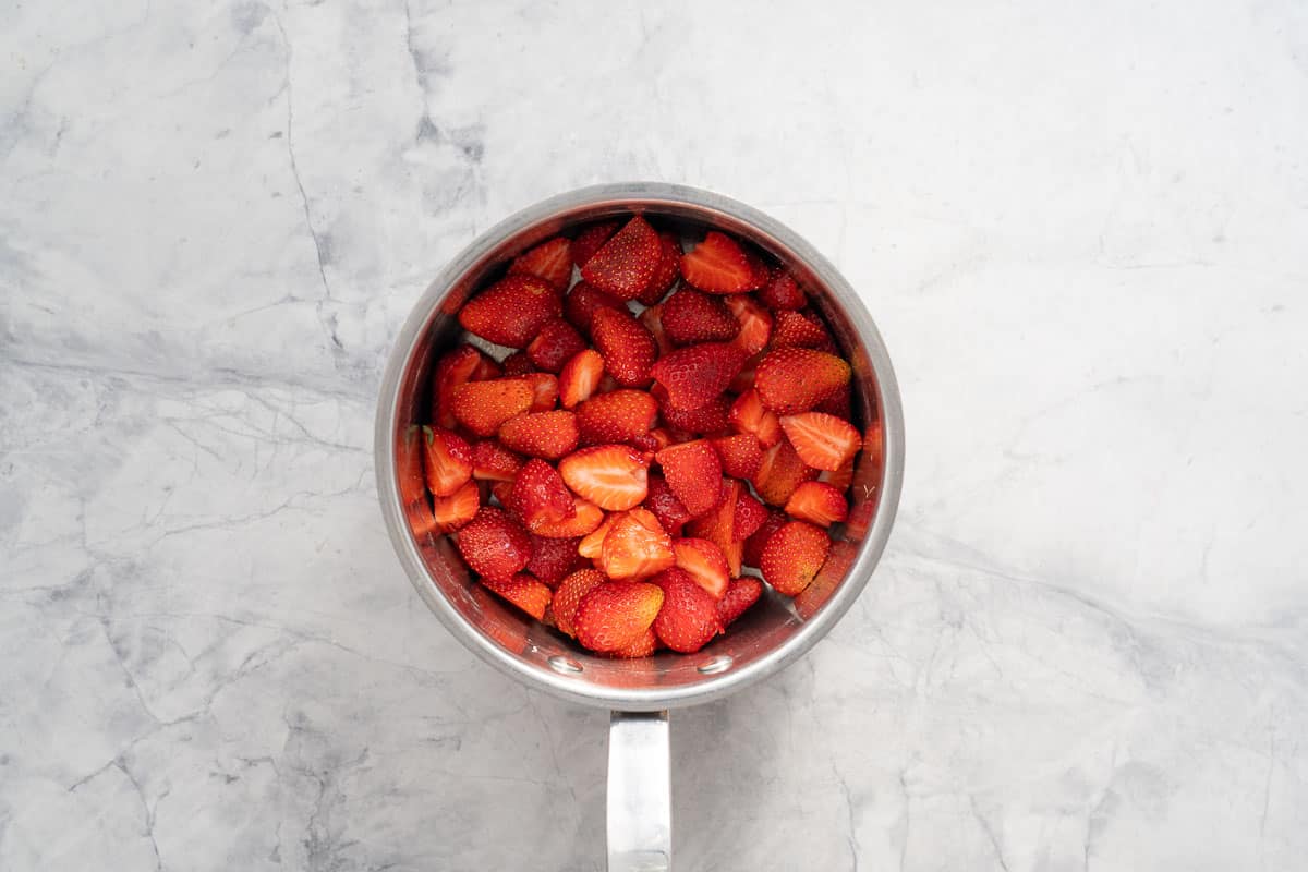 Strawberry halves in a saucepan. 