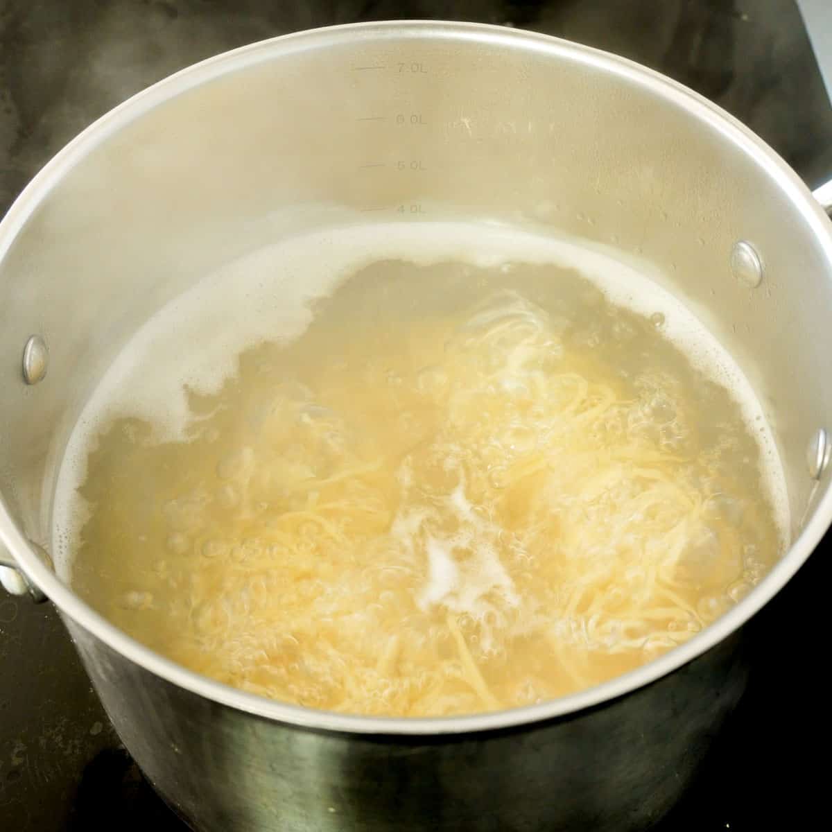 Pasta boiling on the cooktop in a large pot of water 