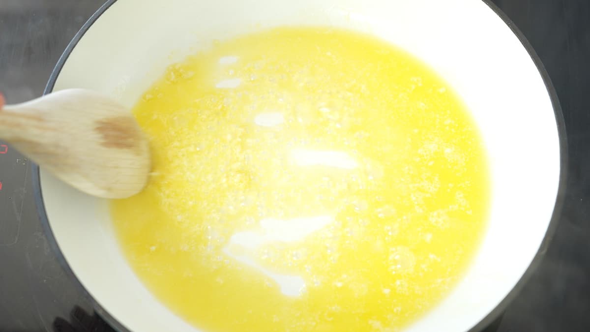 Butter and garlic sauteing in a large pan on the cooktop 