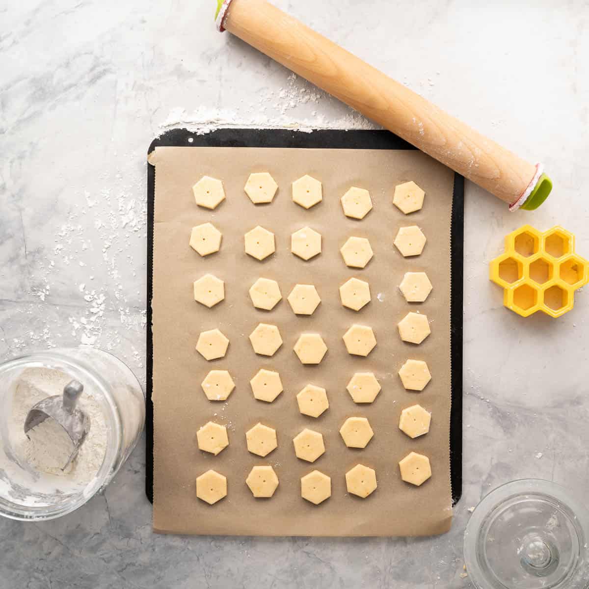 Small hexagon shaped crackers resting on a lined baking tray, ready for the oven