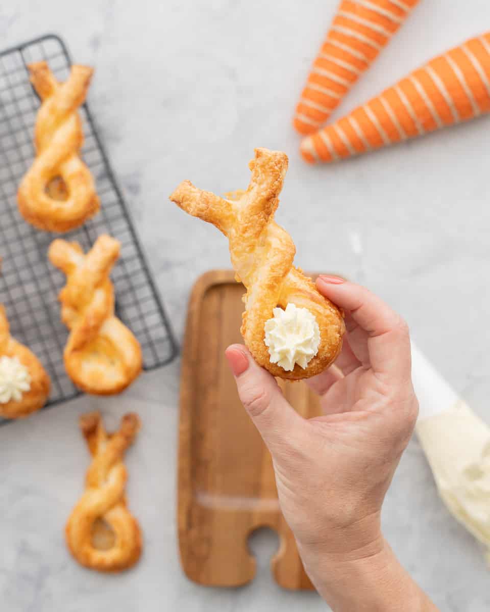 Golden brown strip of puff pastry in a bunny shape with a piped blob of cream cheese to form a bunny tail. 
