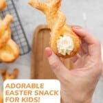 A puff pastry bunny twist with piped cram cheese tail being held up to the camera, with text overlay: Adorable Easter Snack For Kids!.