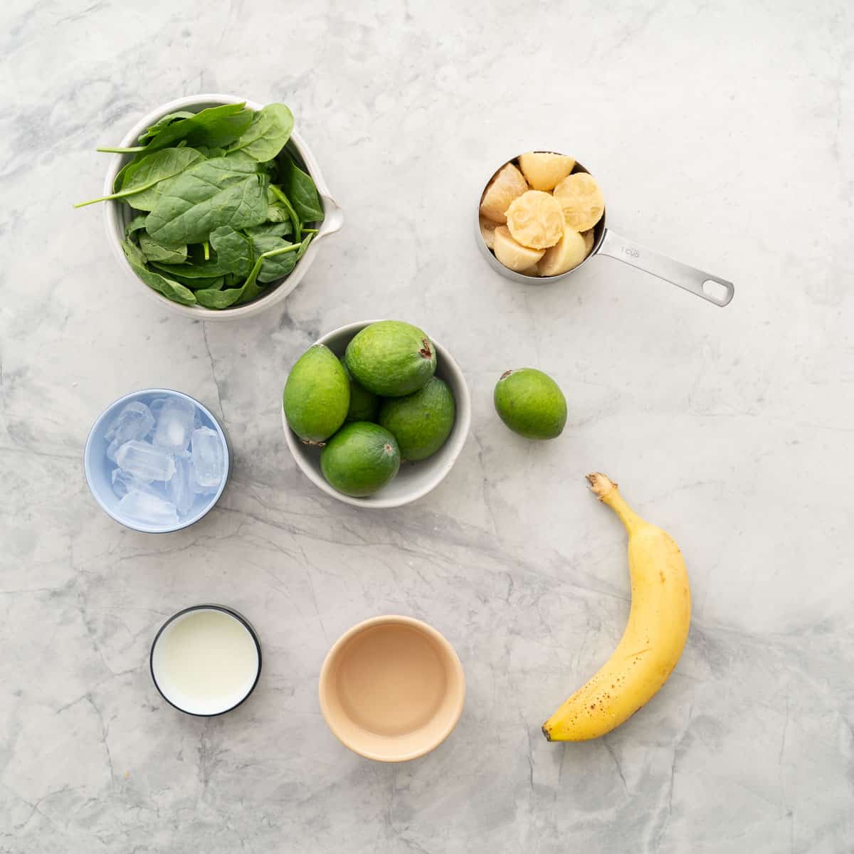 The ingredients to make feijoa smoothie laid out on a bench top.