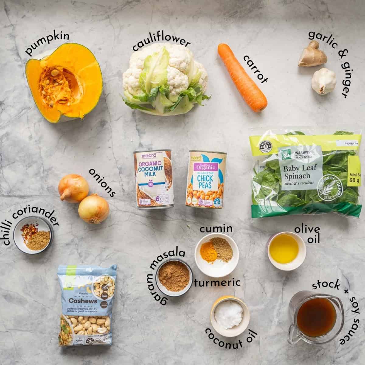 The ingredients to make chickpea curry laid out on a bench top with text overlay ingredient names. 