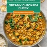 A skillet of chickpea and pumpkin curry next to a bowls of rice, poppadoms, relish, coconut flakes and cashews.With text overlay for pinterest: Creamy chickpea curry.