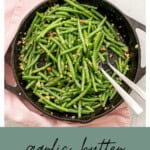 A cast iron skillet of green beans coated in butter with garlic and almond pieces visible with text overlay: Garlic green beans.