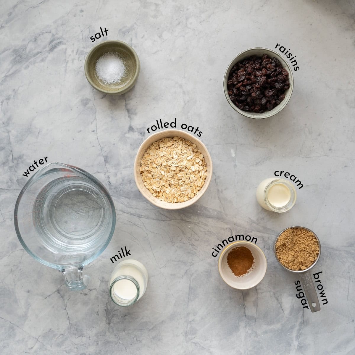 The ingredients to make oatmeal with brown sugar cinnamon topping laid out on a bench top with text overlay labels. 