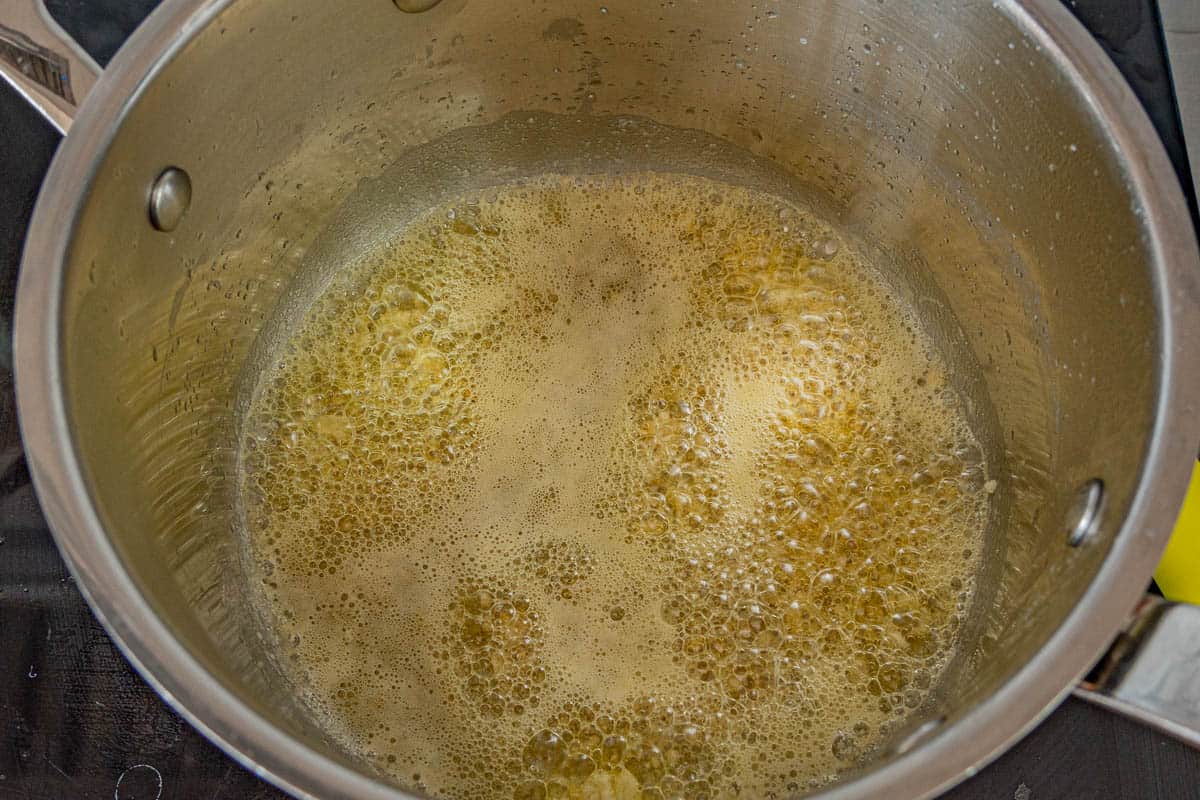 Garlic sizzling in melted butter in the bottom of a saucepan. 