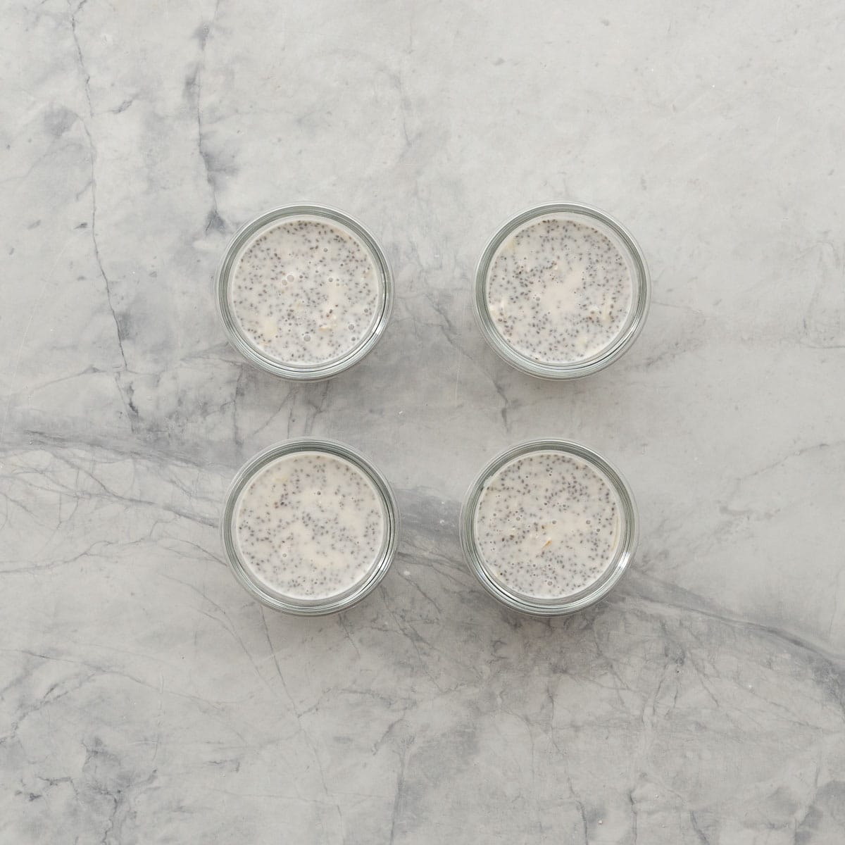 Birds eye view of four containers filled with coconut chia pudding.