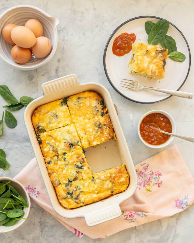 A portion of egg bake hash brown removed from baking dish and served on a plate with chutney.