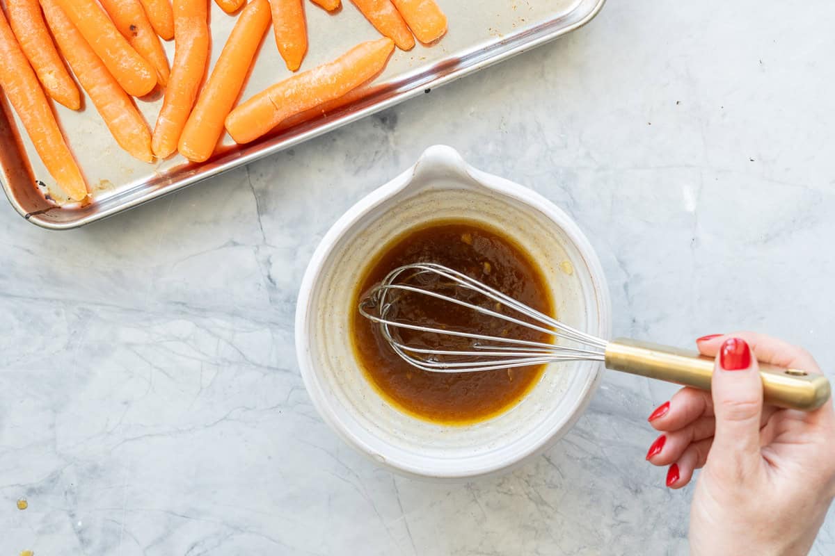 Marinade being stirred in a bowl with a whisk.