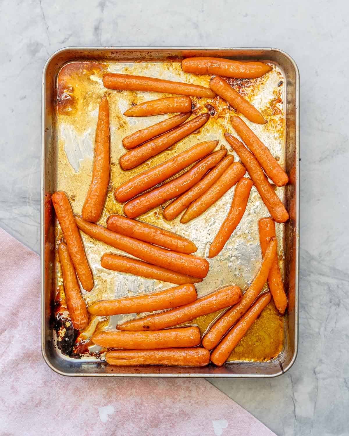 Caramelised honey glazed carrots in baking tray hot out of oven.