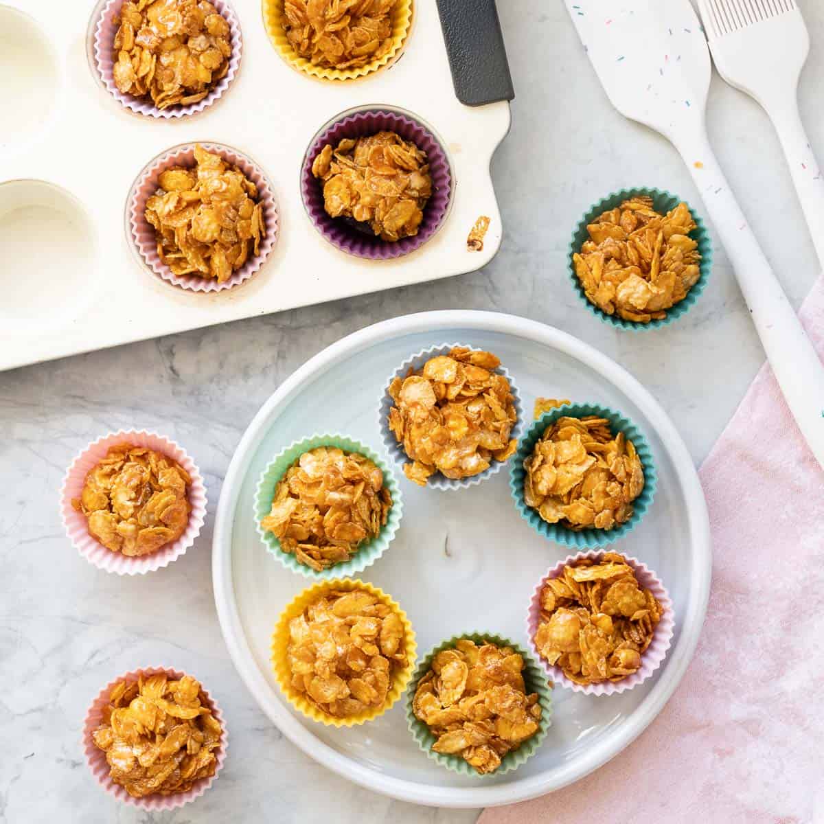 Honey joys in a circle on a plate along with a tray of more.