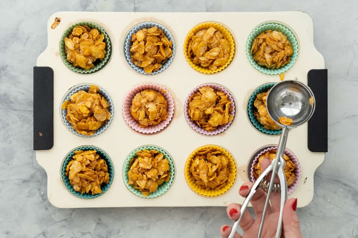 A tray of made honey joys with a scooping tool.