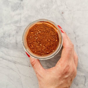 Jar with lid of showing inside of with Mexican seasoning ingredients combined.