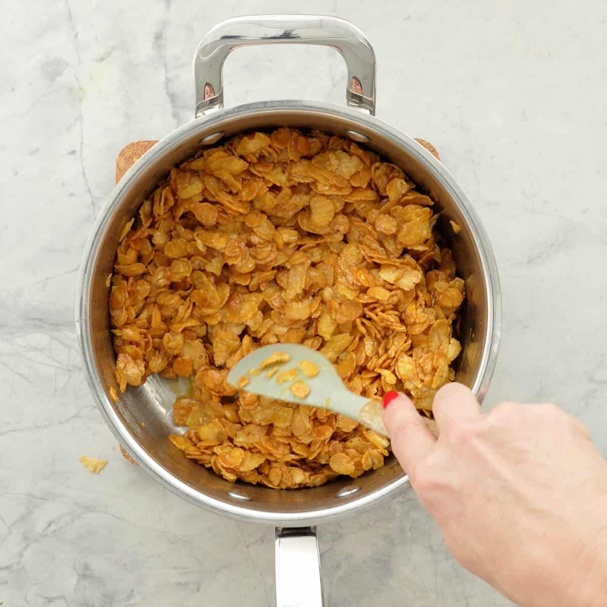 A large space pan of cornflakes mixed with honey caramel. 