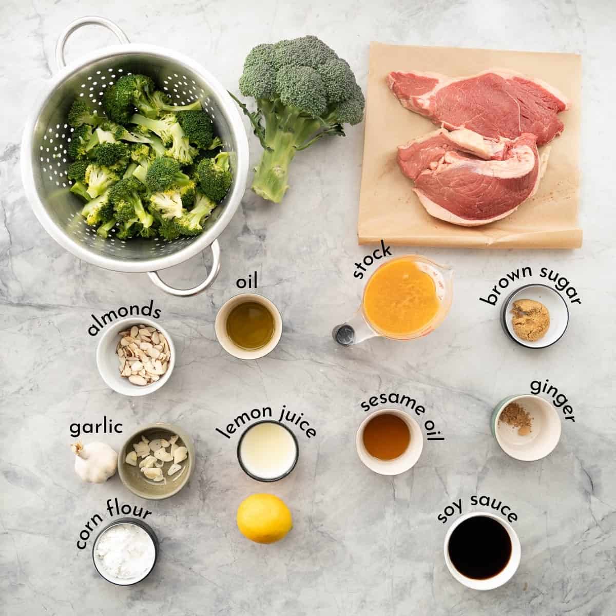 Ingredients for beef and broccoli stir fry portioned and laid out on bench top with ingredient label text overlays.