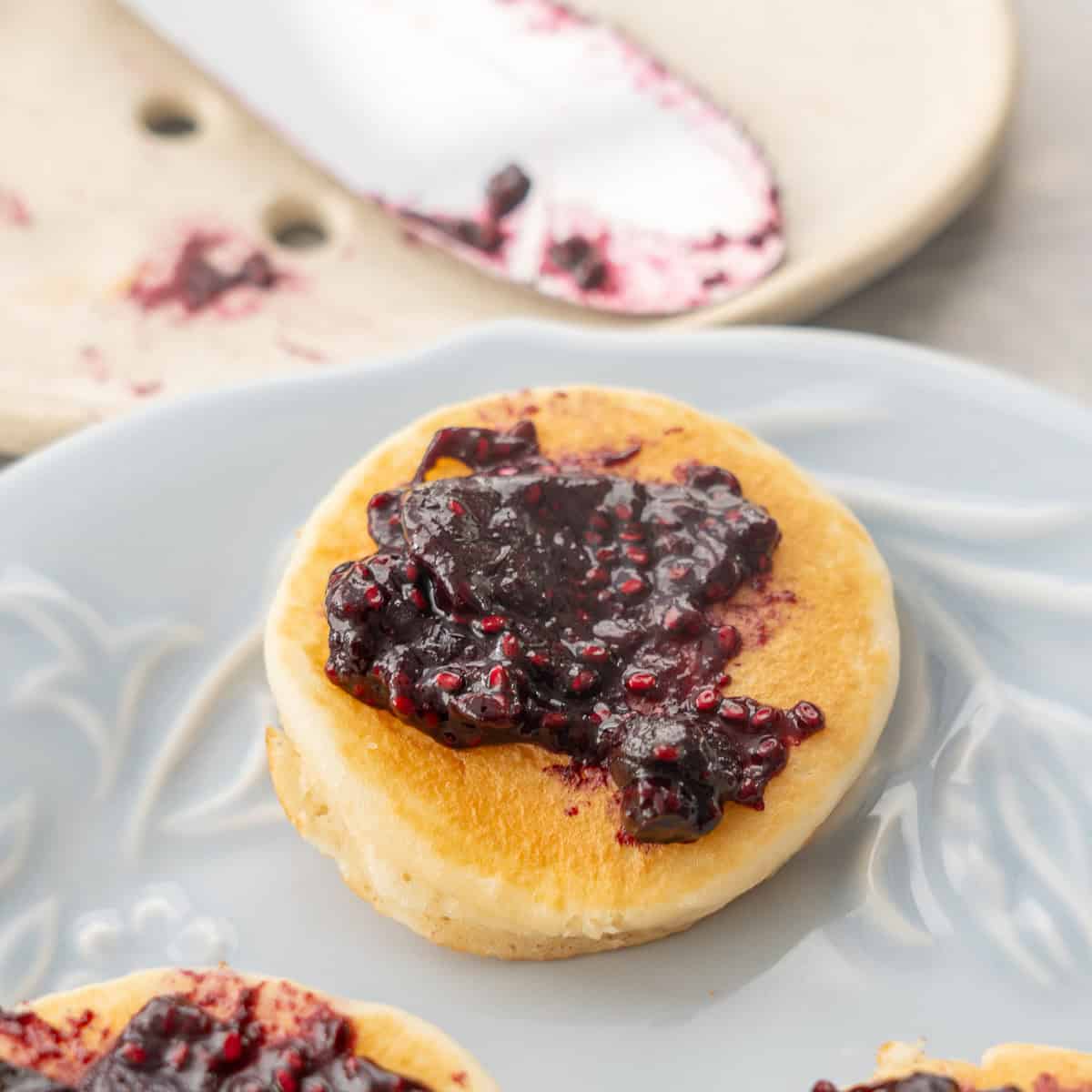 Mini pancake with blueberry chia jam spread on.