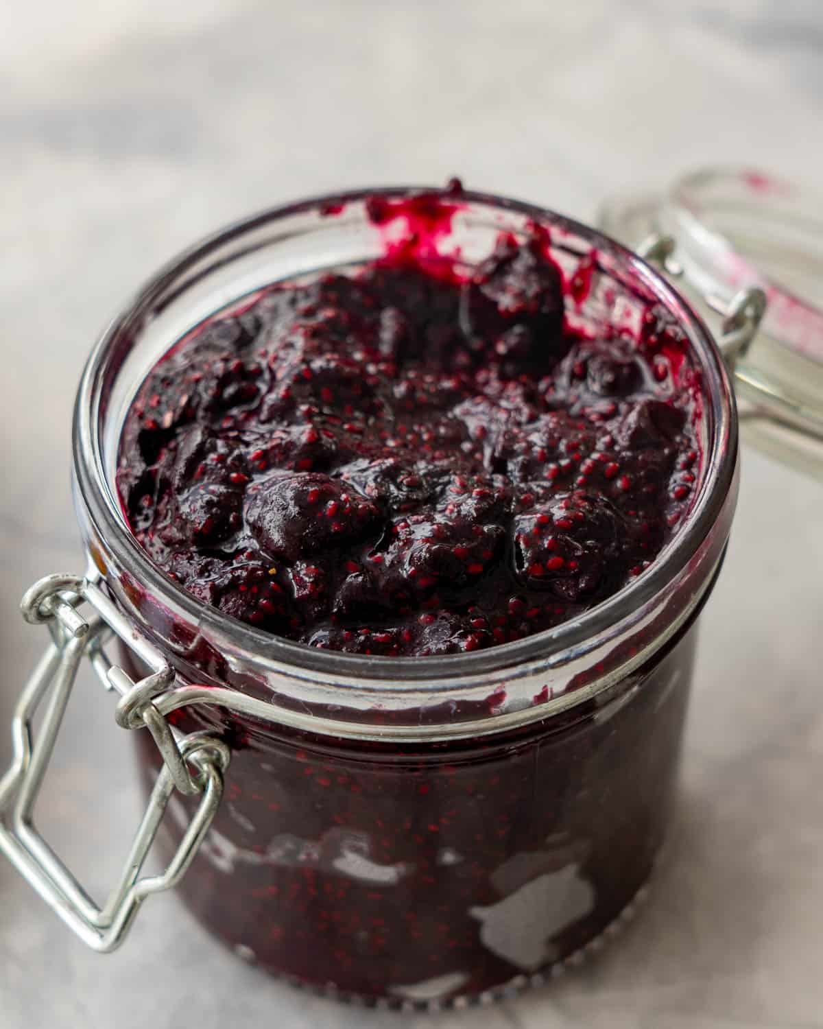 Open jar with blueberry chia jam filled to the top.