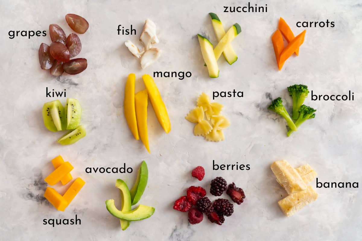 Fruits, vegetables and soft proteins cut up as finger foods to serve a baby with text overlay.