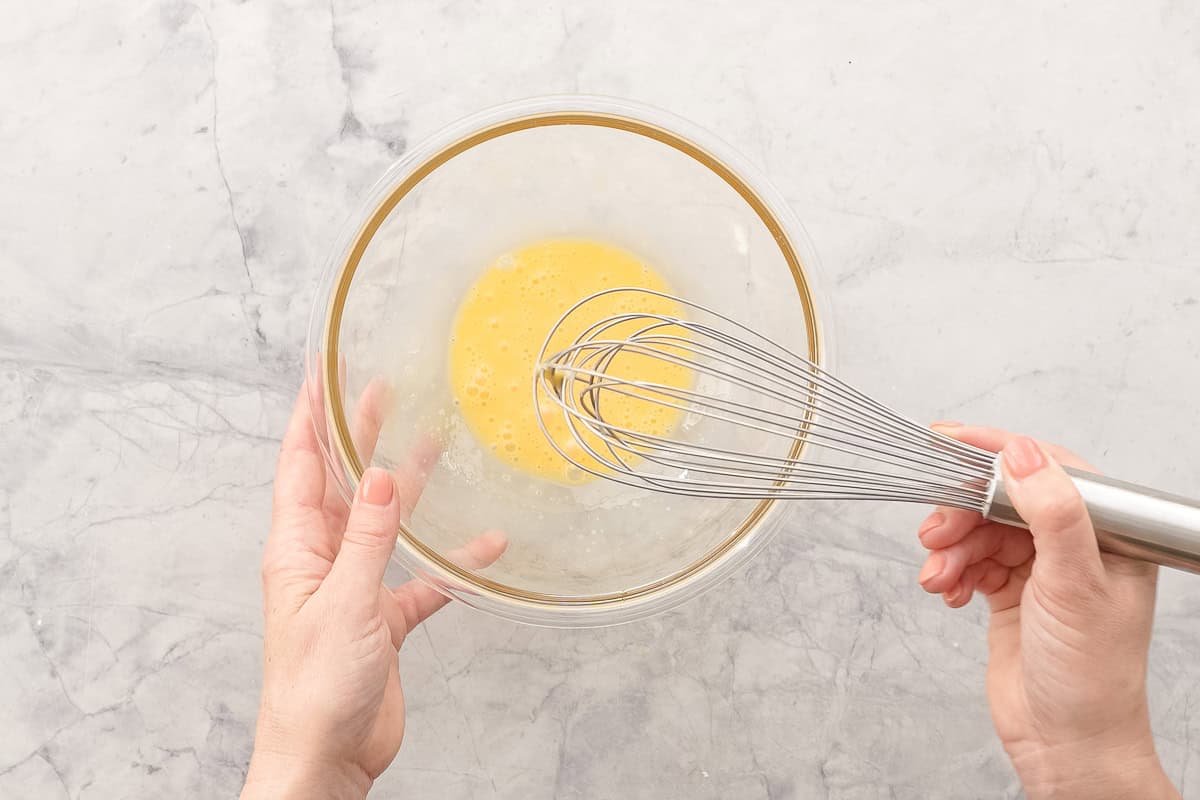 Egg being whisked in bowl.