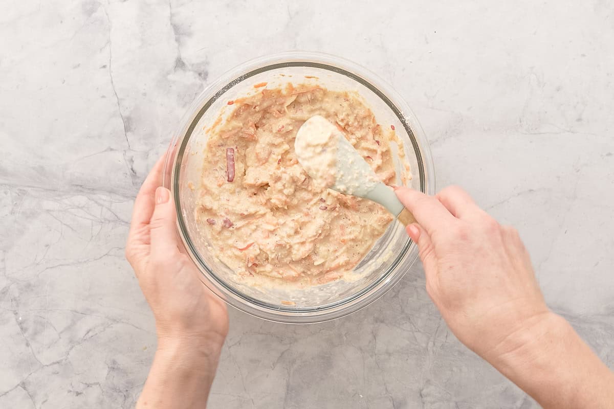 Batter for carrot cake pancakes being mixed with spatular.