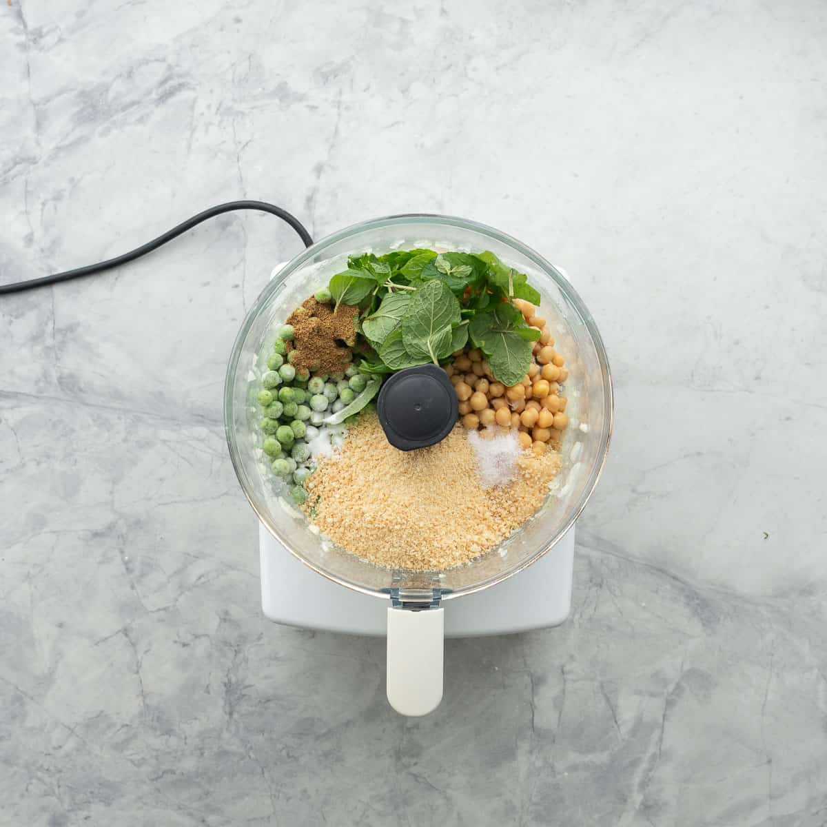 Ingredients for Chickpea patties inside food processor before being blended.