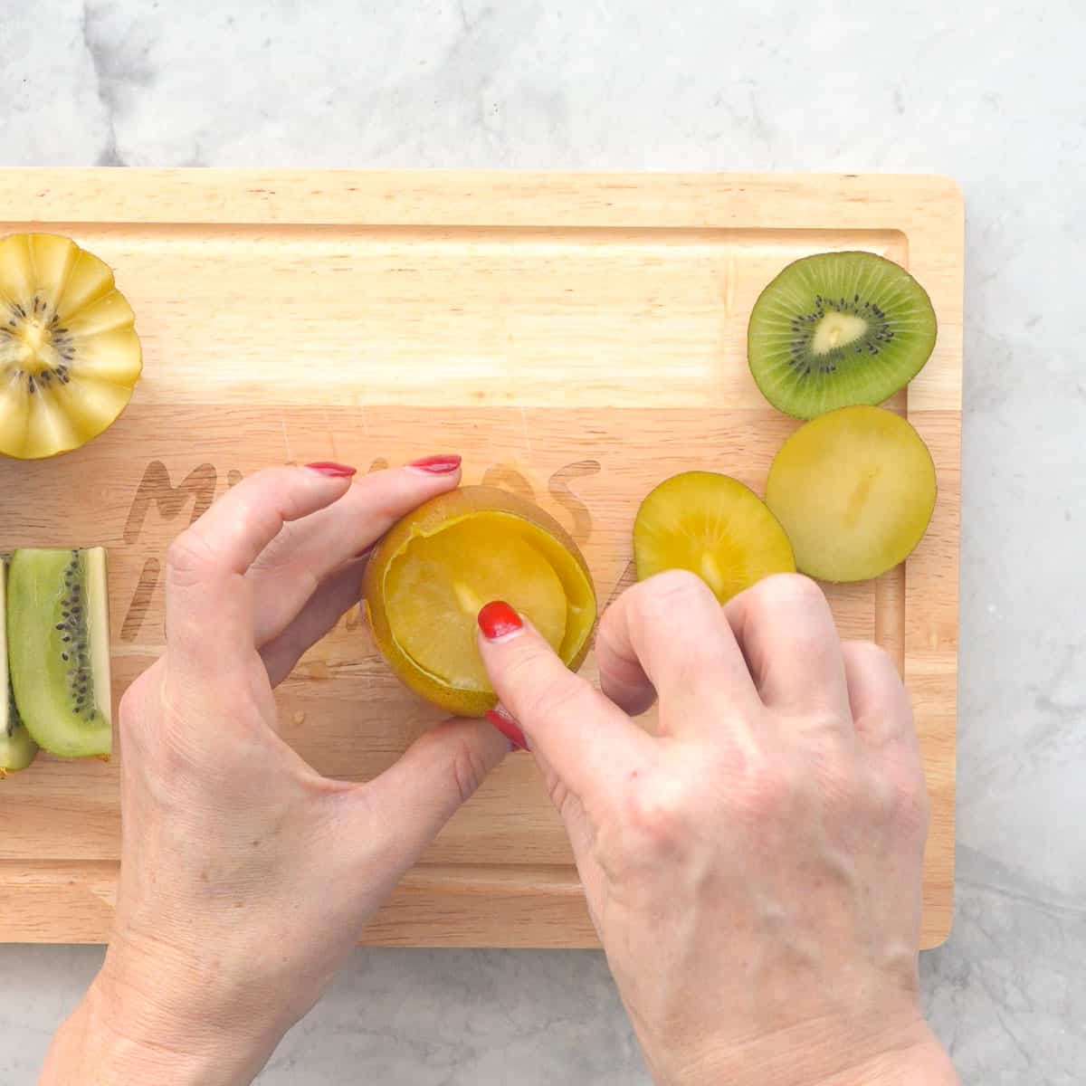 The flesh being removed from the peel of a kiwifruit in one piece. 