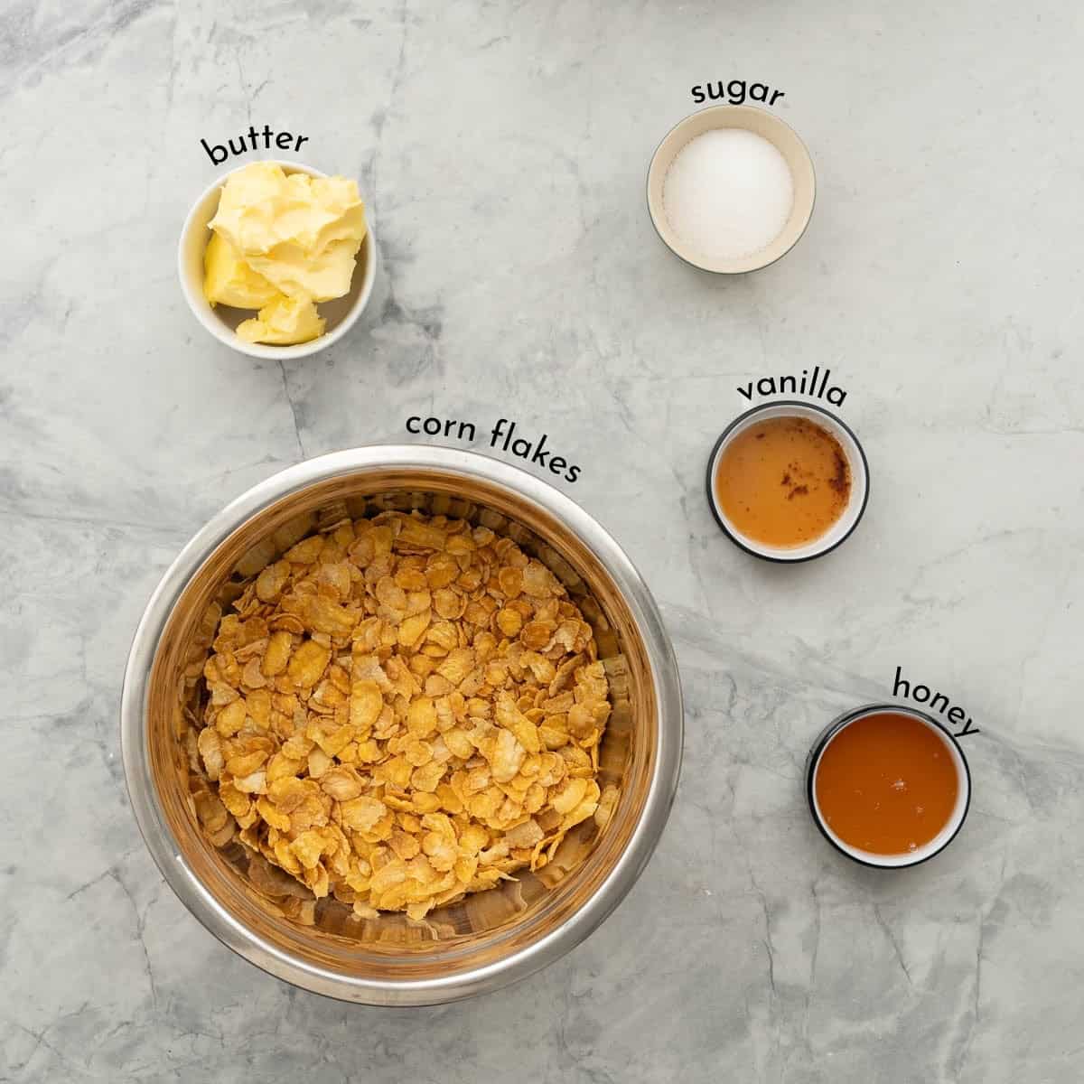 The ingredients to make honey joys laid out on a bench top with text overlay ingredient labels.