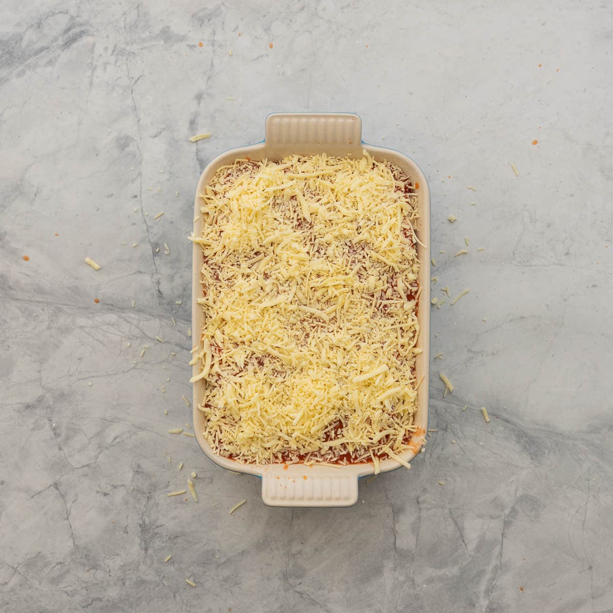 Lazy lasagna with completed layers with grated cheese sprinkled on top.