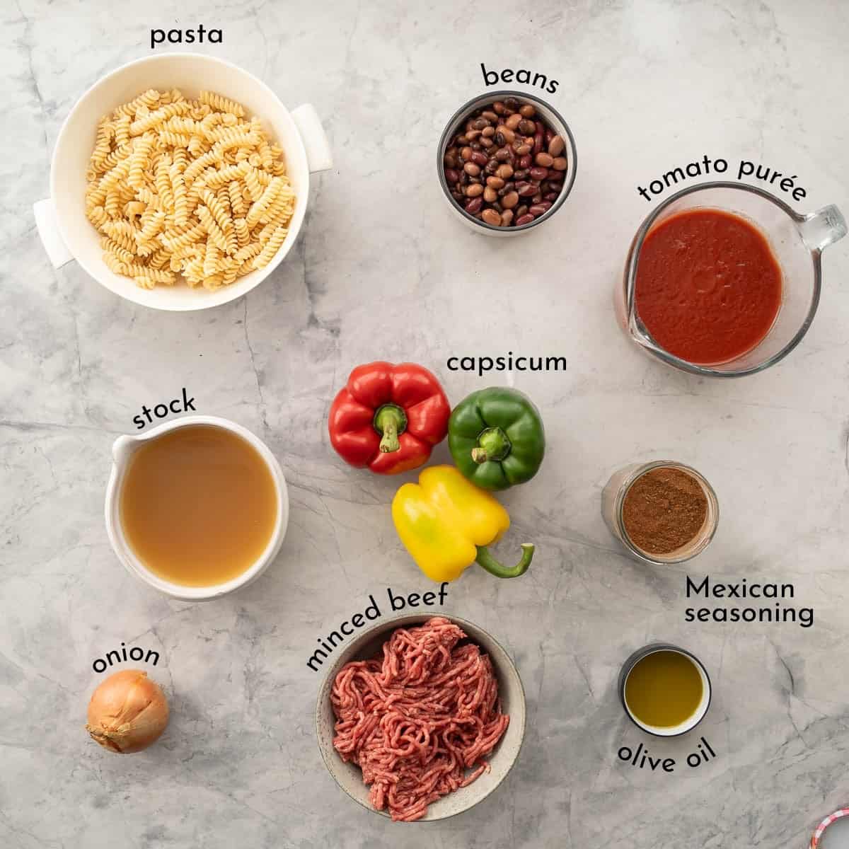 Ingredients for Mexican pasta on bench top with txt overlay.