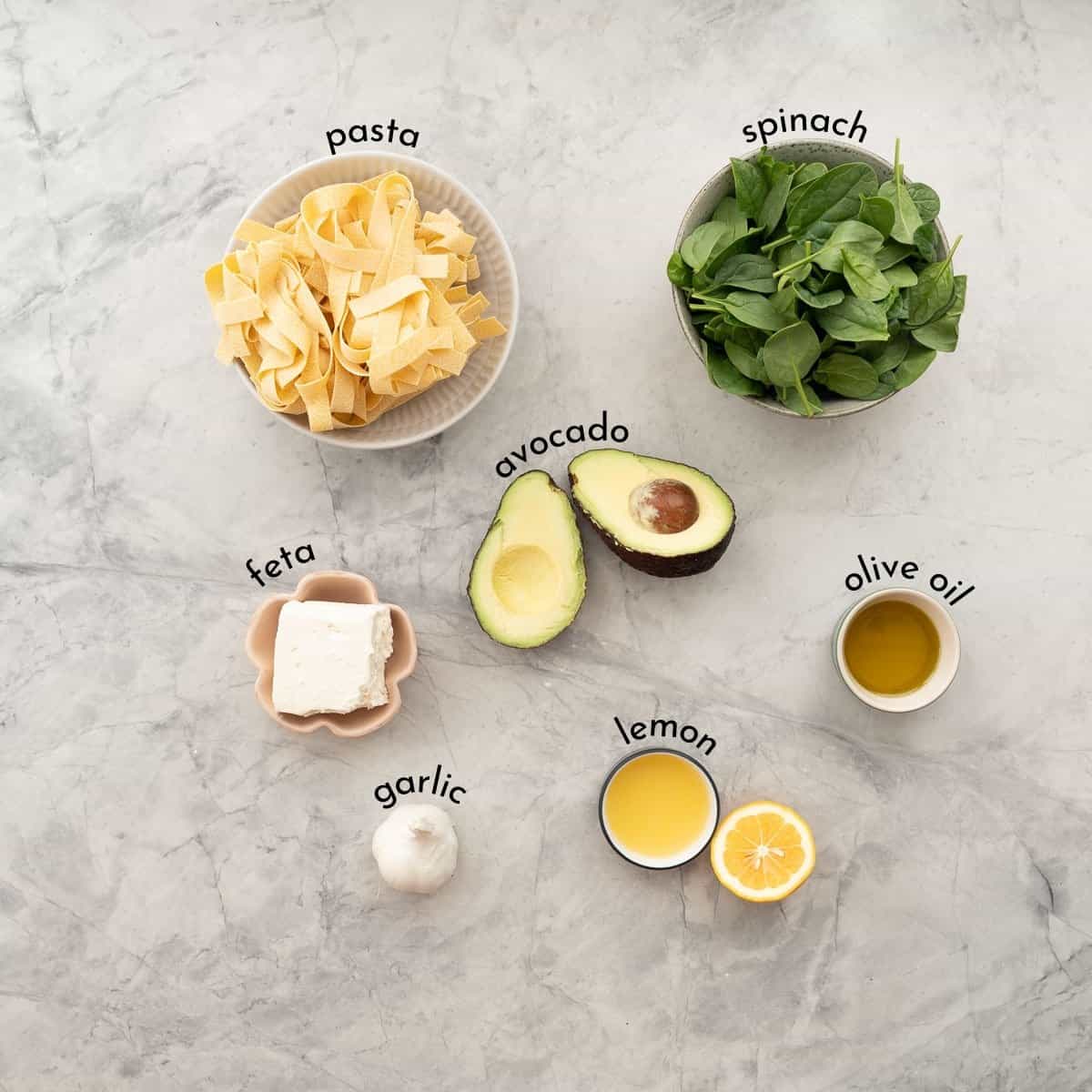 Ingredients for Avocado pasta on a bench top with text overlay.