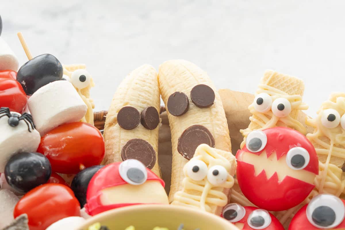 Halloween monsters together, two banana ghosts, three mummy wafers cookies, cheese monsters.