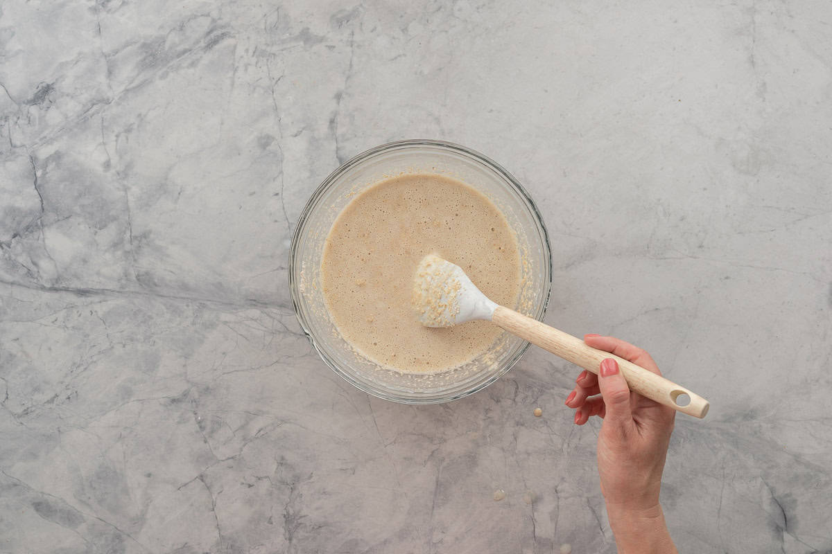 Dry and wet ingredients combined and being stirred with spatula.