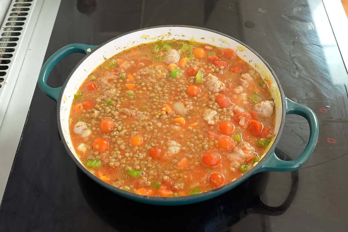 Lentils and sausages added into the pan with tinned tomatoes, stock snd vegetables.