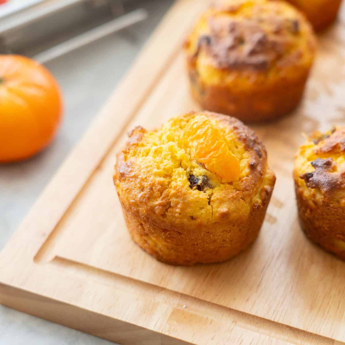 Mandarin muffins on wooden chopping board.