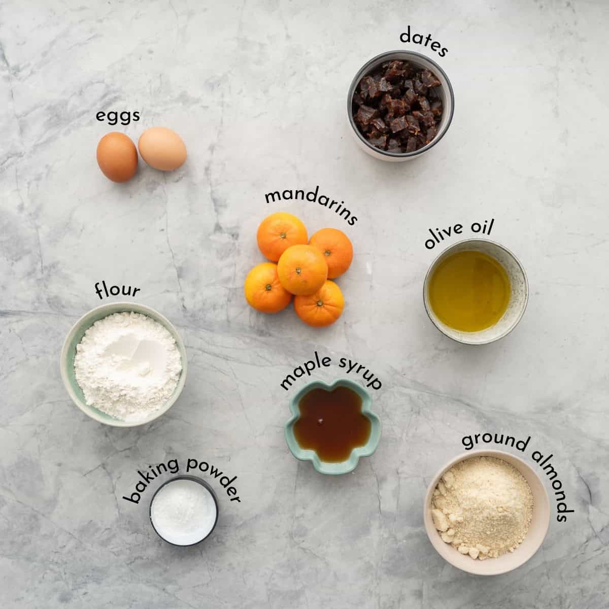 Ingredients for Mandarin muffins on bench top with text overlay.