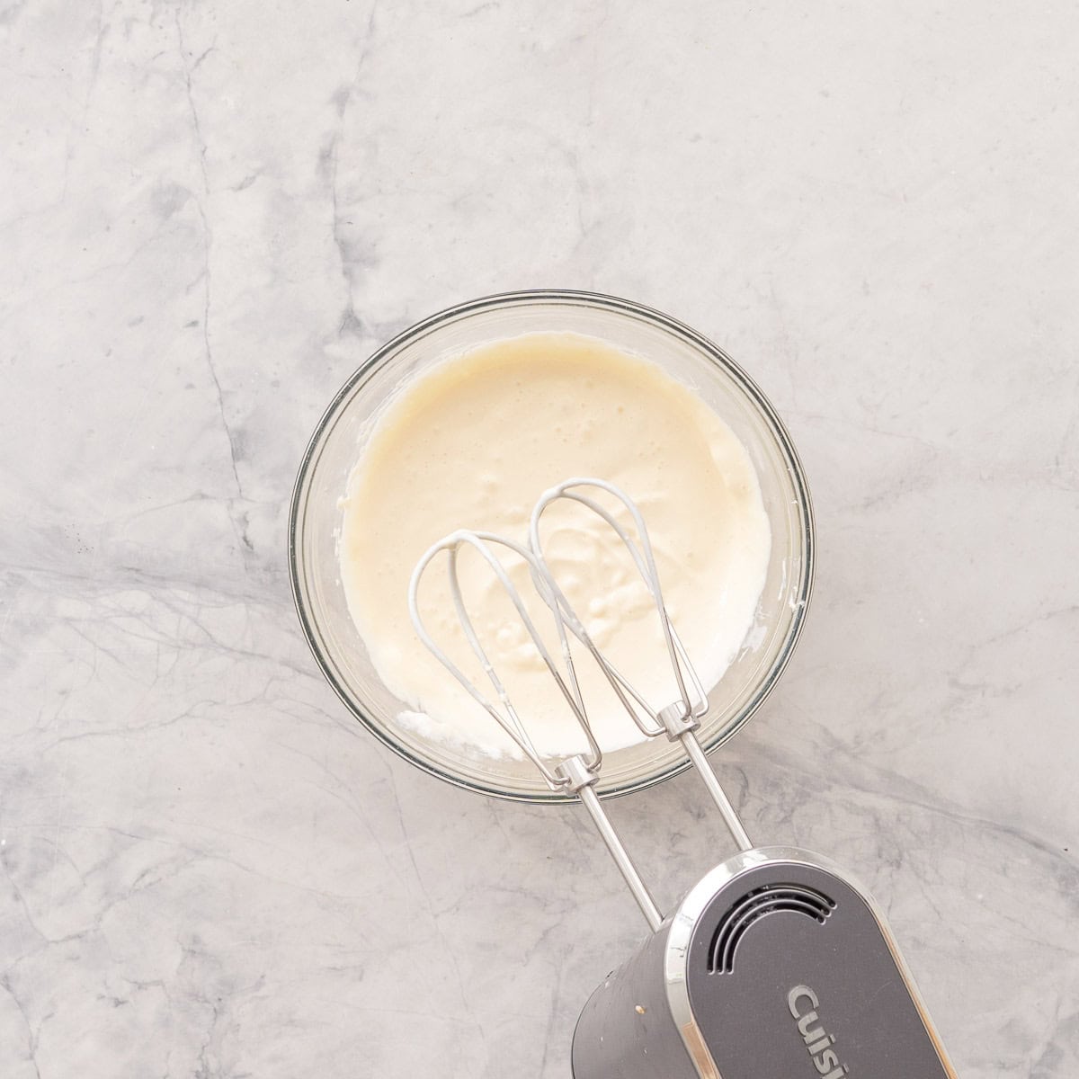 Frosting for Smash cake n a glass bowl on bench top whisked together with an electric beater.