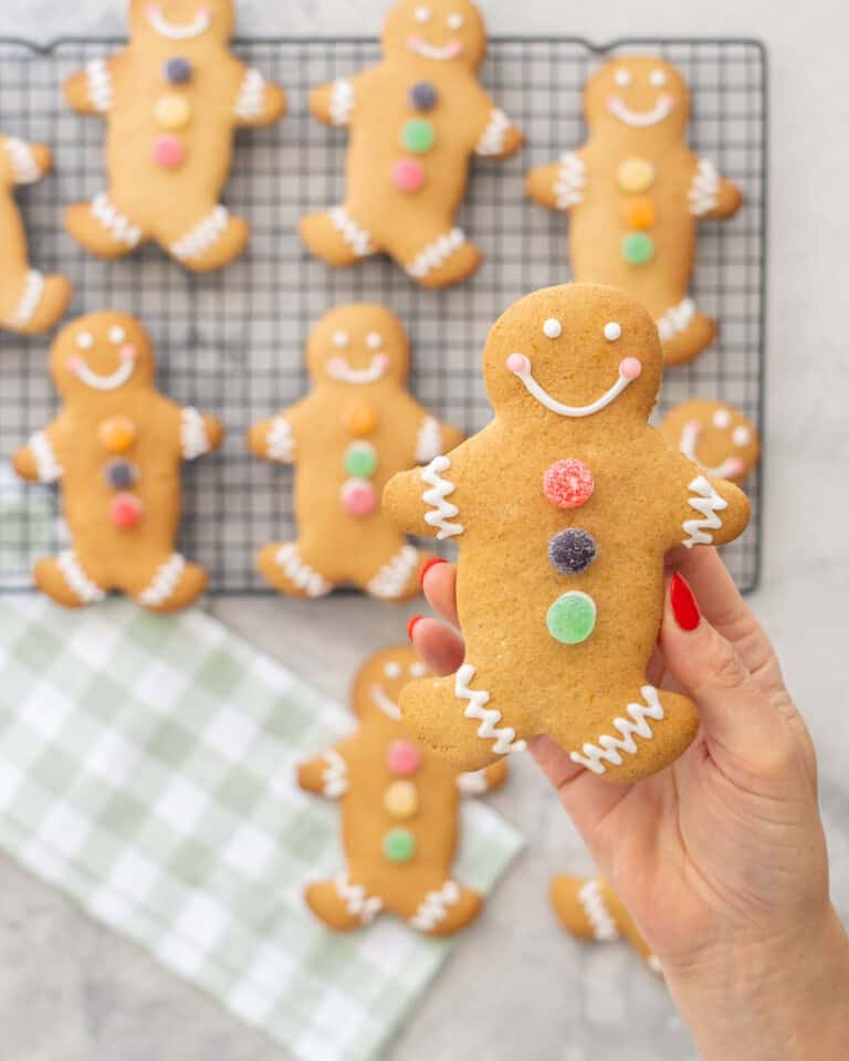 GF Gingerbread held up to the camera decorated with three colourful circle jellys down the centre, royal icing squiggly lines on feet and arms, smiley face.