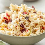 Christmas Popcorn in a ceramic bowl on bench top with Christmas decorations around.