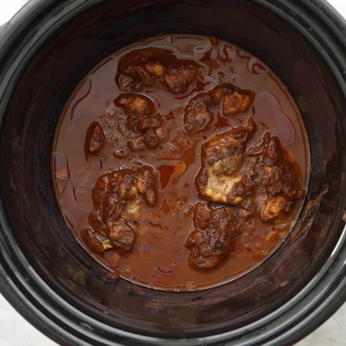 Cooked chicken in sauce in crockpot.