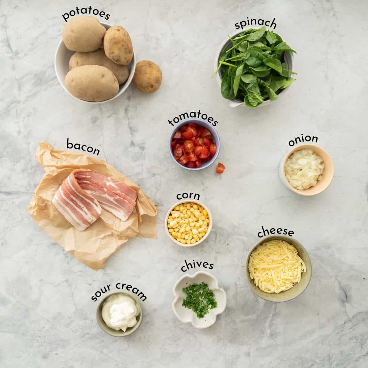 Ingredients for Loaded bakes potatoes on benchtop with text overlay.