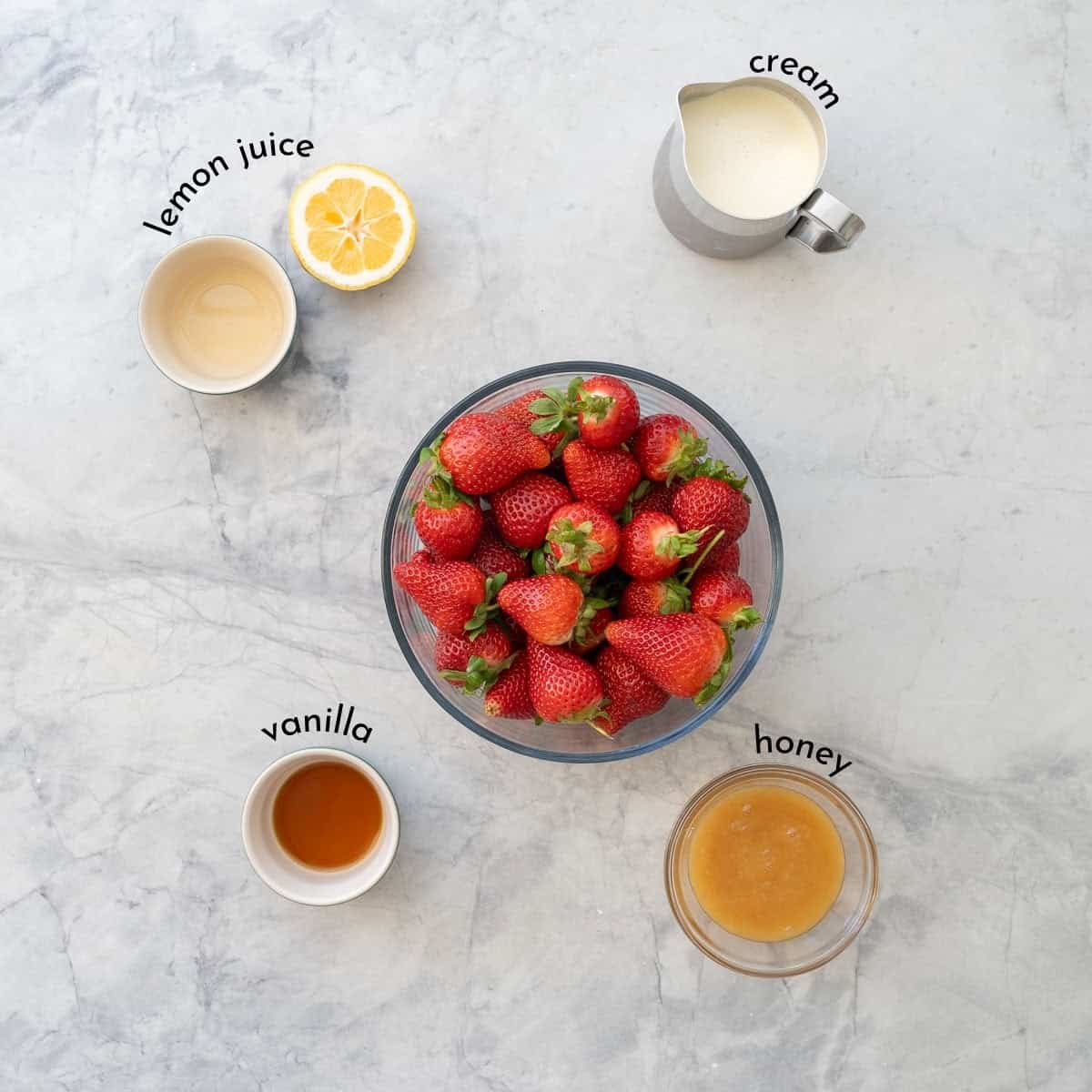 Ingredients for strawberries and cream with text overlay on benchtop.