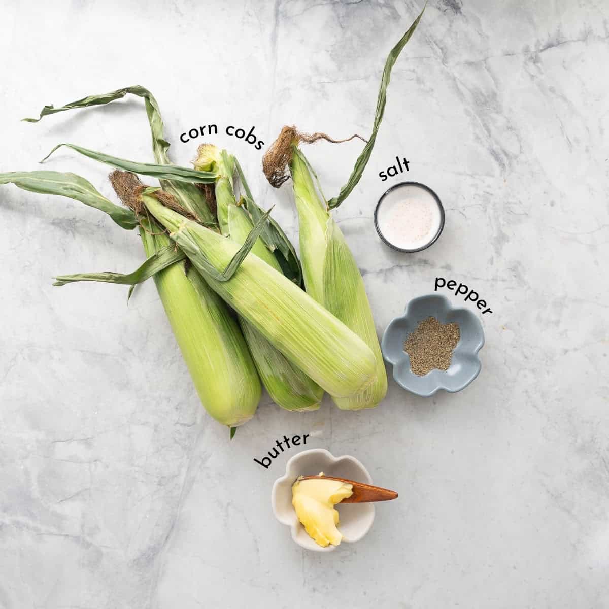 Ingredients for Microwave corn cobs on bench top with text overlay.