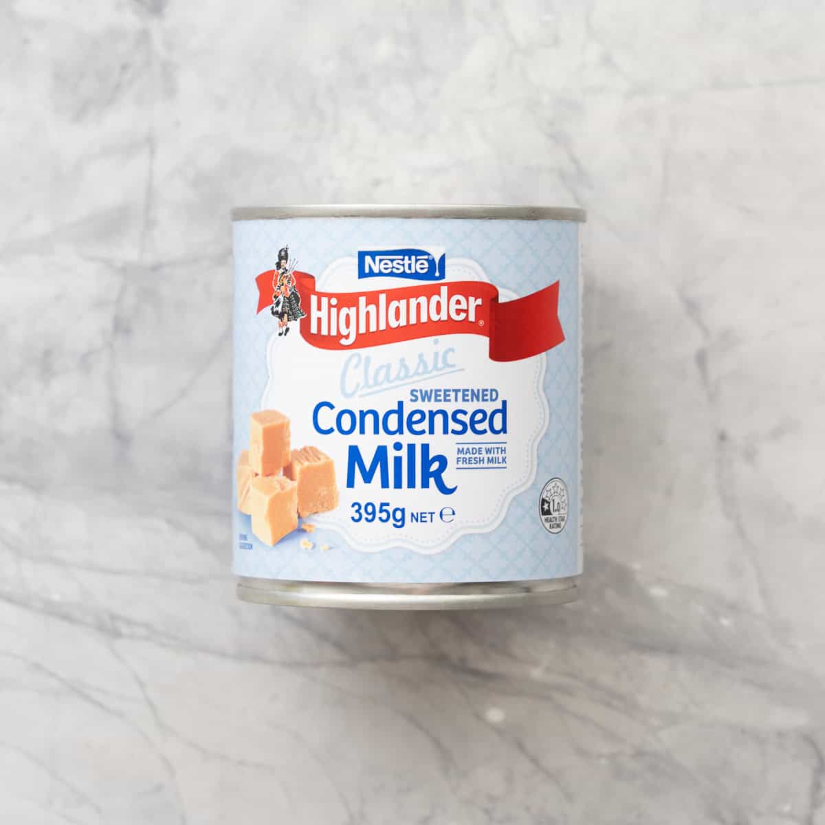 A can of condensed milk on a marble bench top.