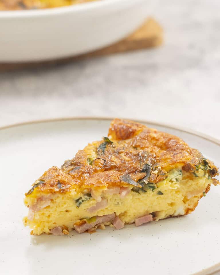 Slice of quiche on dinner plate.